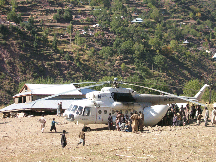 Men and children gathered by cargo helicopter in Pakistan